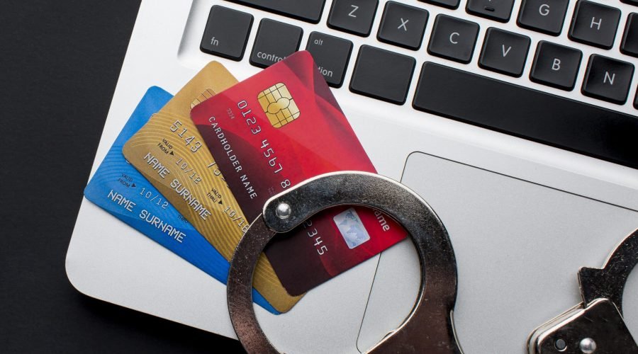 top-view-laptop-with-credit-cards-handcuffs top-view-laptop-with-credit-cards-handcuffs